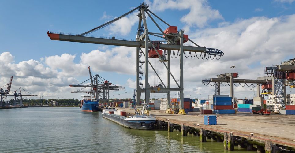 Port terminal with crane in the foreground in good weather.