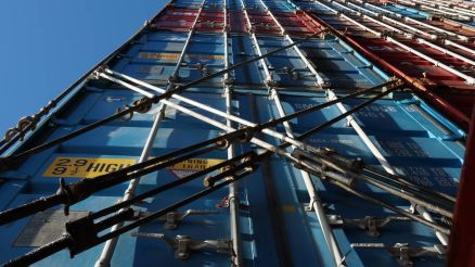 Stack of different colors containers secured on the ship and lashes with lashing bars, turnbuckles and twist locks.