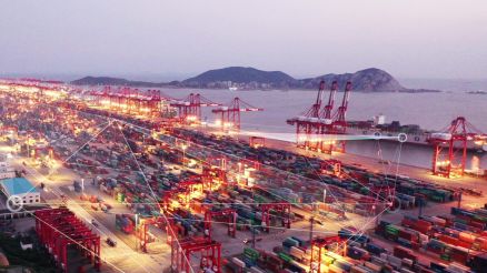 Illuminated container port at dusk. Lines form a network and represent a luminous network of logistics.