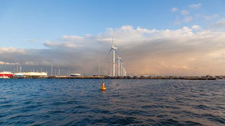 A small to medium-sized European port equipped with wind turbines, showcasing the integration of renewable energy into maritime infrastructure as part of the EU’s green transition.
