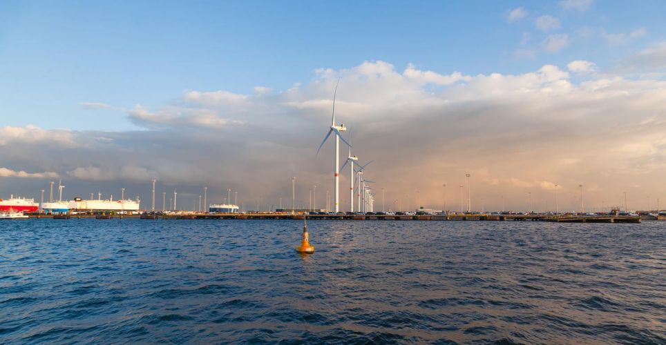 A small to medium-sized European port equipped with wind turbines, showcasing the integration of renewable energy into maritime infrastructure as part of the EU’s green transition.