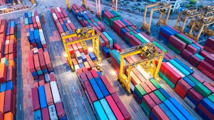 Bird's eye view of the lightly lit container port in the evening.